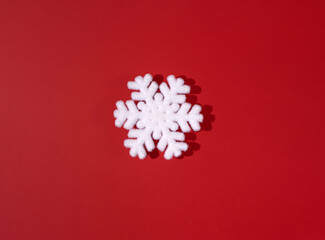 Snowflake, Christmas decoration against rich red background. Minimal, traditional, winter holidays layout. 