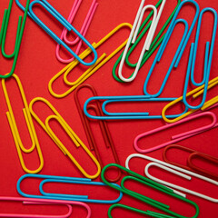 colorful paper clips on a red background. School, and eduaction idea.
