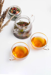 Teapot, cup of herbal tea with berries on white table. Still life of organic, natural berry tea, copy space.