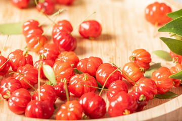 Pitangas placed on a wooden plate on a white plastic tablecloth on the table, selective focus.