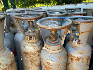 Many various older portable gas cylinders in front of gas store for service