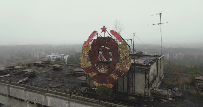 Drone view close up over the sign of USSR on the roof in city of Pripyat near the Chernobyl nuclear power plant in Chernobyl exclusion zone. Ukraine. Ghost city after disaster