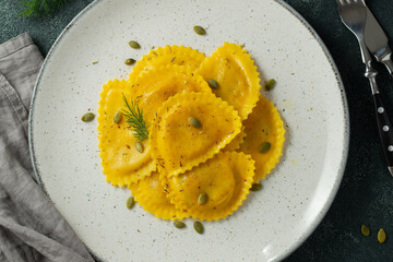 Homemade Pumpkin Ravioli with butter on a dark concrete background. Top view