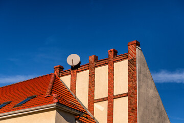 satellite dish on a house roof in sunlight