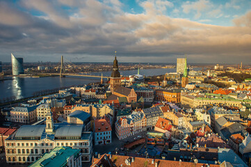 Fototapeta na wymiar Panorama of the city of Riga on a sunny day, morning, sunset, a view of the old town, narrow streets, red brick roofs of houses, cathedrals, a river and bridge.