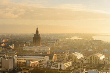 Panorama of the city of Riga on a sunny day, morning, sunset, a view of the old town, narrow streets, red brick roofs of houses, a river and bridge.