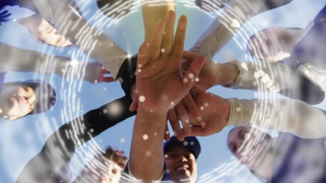 Animation of circles and spots of light over hands of diverse sport team