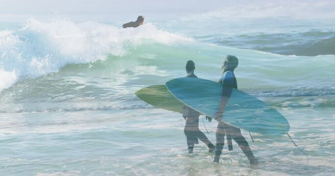 Animation of man surfing over diverse senior couple walking on beach with surfing board