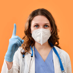 The doctor makes a careful finger - up gesture, copy space. A woman in medical protective gloves and a mask on a red background, concept