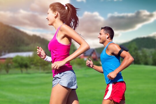 Portrait of a young couple running and exercising in a city park outdoors