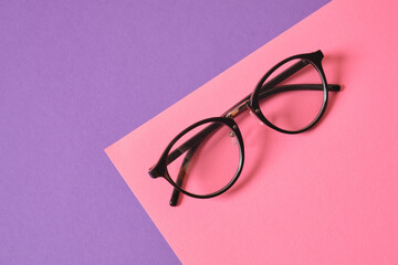 eyeglasses on pink and purple geometric background, trendy eyeglass frames copy space