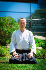  Young serious man aikido master in traditional costume