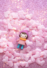cute baby doll and pink hearts concfetti on glitter pink background. 14 february holiday, Valentine's day, Love, romance concept. flat lay