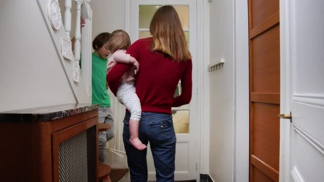 Excited woman and kids open door to Christmas tree