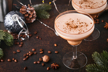Alexander cocktail in cocktail glass on wooden table with shaker, nutmeg and small grater with Christmas decor on dark background. Beverage photography. Festive cocktail drink. - obrazy, fototapety, plakaty