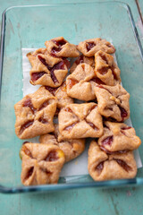 Czech cheesecake pastry folded cubes baskets biscuits wrapped filled with red jam on rustic scratched vintage background