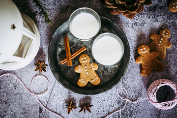 Bonhomme en pain d'épices à la cannelle et verres de lait sur une table de fête