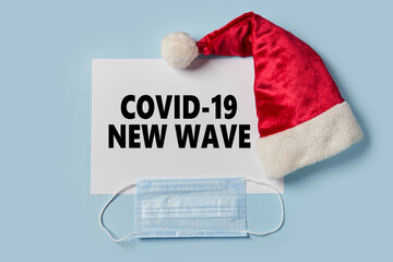 Covid-19 new wave during Christmas holidays. Santa Claus cap and surgical face mask. Coronavirus...