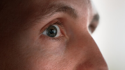 The young man glances from side to side. Close-up