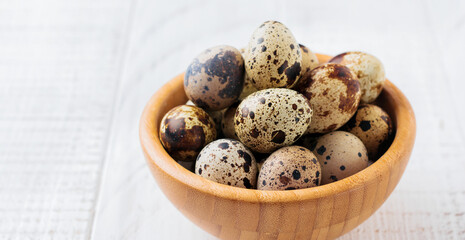 Obraz premium Quail eggs in metal plate on white wooden old background. Selective focus.