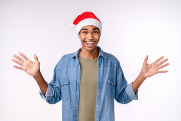 Fototapeta na wymiar Amazed excited cheerful young african man teenager boy in Santa`s red hat feeling surprised shocked while waiting for Christmas New Year celebration winter holiday isolated on white