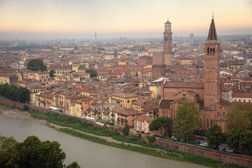 Fototapeta na wymiar Aerial view of the beautiful city of Verona with the Bell Tower of Saint Anastasia and Laberti Tower at a cloudy sunrise, Veneto region, Italy