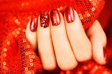Beautiful festive manicure of bright red color. Female hand with a beautiful manicure.