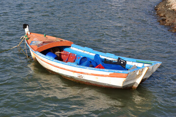 Naklejka na ściany i meble Wooden Fishing Boat Floating on Choppy Water 