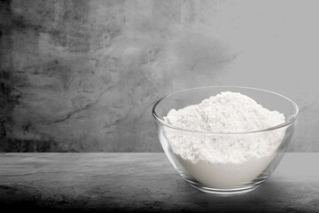 Pile of flour, on dark or black background. Spilled flour. Flour texture.