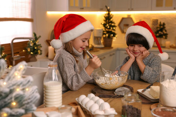 Cute little children making dough for Christmas cookies in kitchen