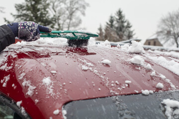 Oczyszczanie dachu auta z zalegającego śniegu  - obrazy, fototapety, plakaty