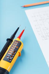 Two-pole voltage indicator with electrical drawings on a blue background.