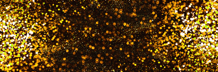 Golden sparkling Christmas abstract background. Festive concept. Defocused background with glitter. Banner.