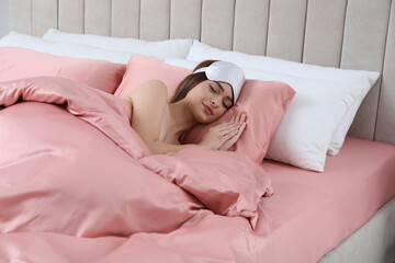 Young woman sleeping in comfortable bed with silky linens
