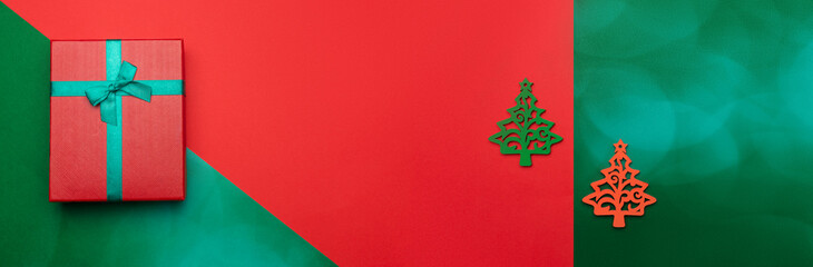 Naklejka na ściany i meble Festive background with toy in the form of Christmas tree and gift box. Christmas background with copyspace. Holiday concept. Banner.