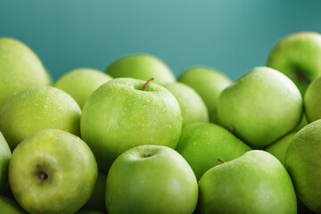Ripe and juicy green apples on a green background.
