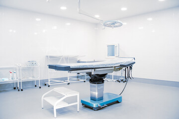 Empty operating room in a hospital. Surgical equipment with operating table. Medical device for emergency patient in blue tone style. Blank Emergency Surgery Room. Clinic interior for background.