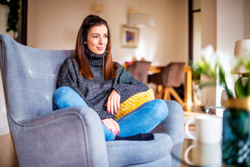 Woman relaxing at the armchair at home