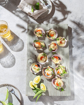 Summer table with baked ostions with cheese. Sunlight immitation, top view