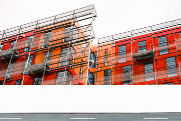 Modern construction site with scaffolding and blank information fence, hoarding with copy space for branding  © BOOCYS