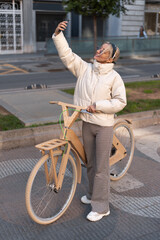 Female bicyclist taking selfie on street