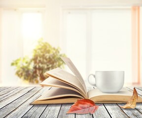 season, leisure and objects concept, a cup of coffee, book, autumn leaves