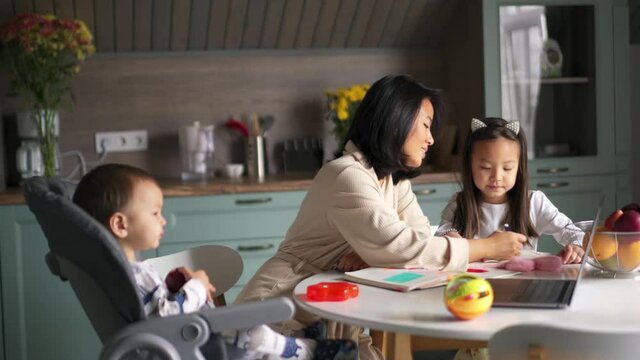 Positive Asian family painting in the kitchen 