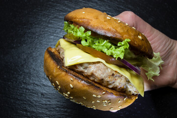 cooked burger with lettuce in hand