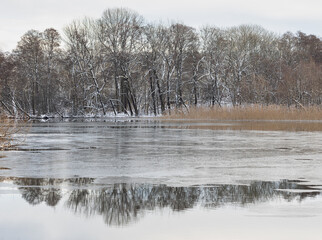 Landscape with frozen lake in winter. - 473381236