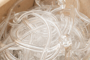 Broken clear glass pipes prepared for recycling and decorative items manufacturing in large wooden...