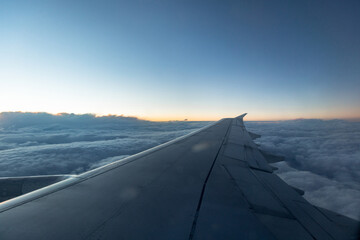 Fototapeta na wymiar beautiful view of the plane wing, blue clouds and sunset