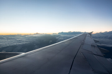 beautiful view of the plane wing, blue clouds and sunset