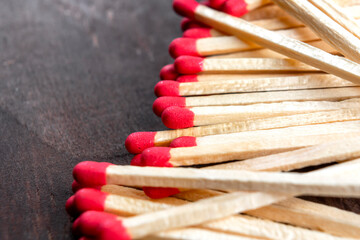 Matches with red sulfur on a dark wooden background. Macro