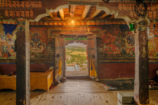 Ancient Thiksey monastery with view of murals on the inside wall and Himalayan mountians outside - it is a famous Buddhist temple in,Leh, Ladakh, Jammu and Kashmir, India.